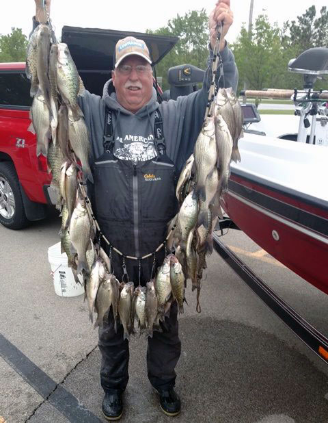 Steve Welch holding up a line of fish